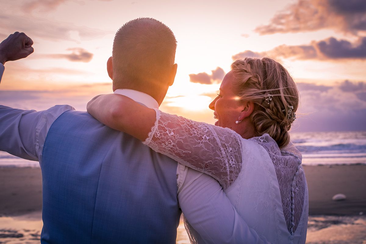Trouwen op Texel, zonsondergang op het strand met het bruidspaar op de foto, trouwfotograaf Texel