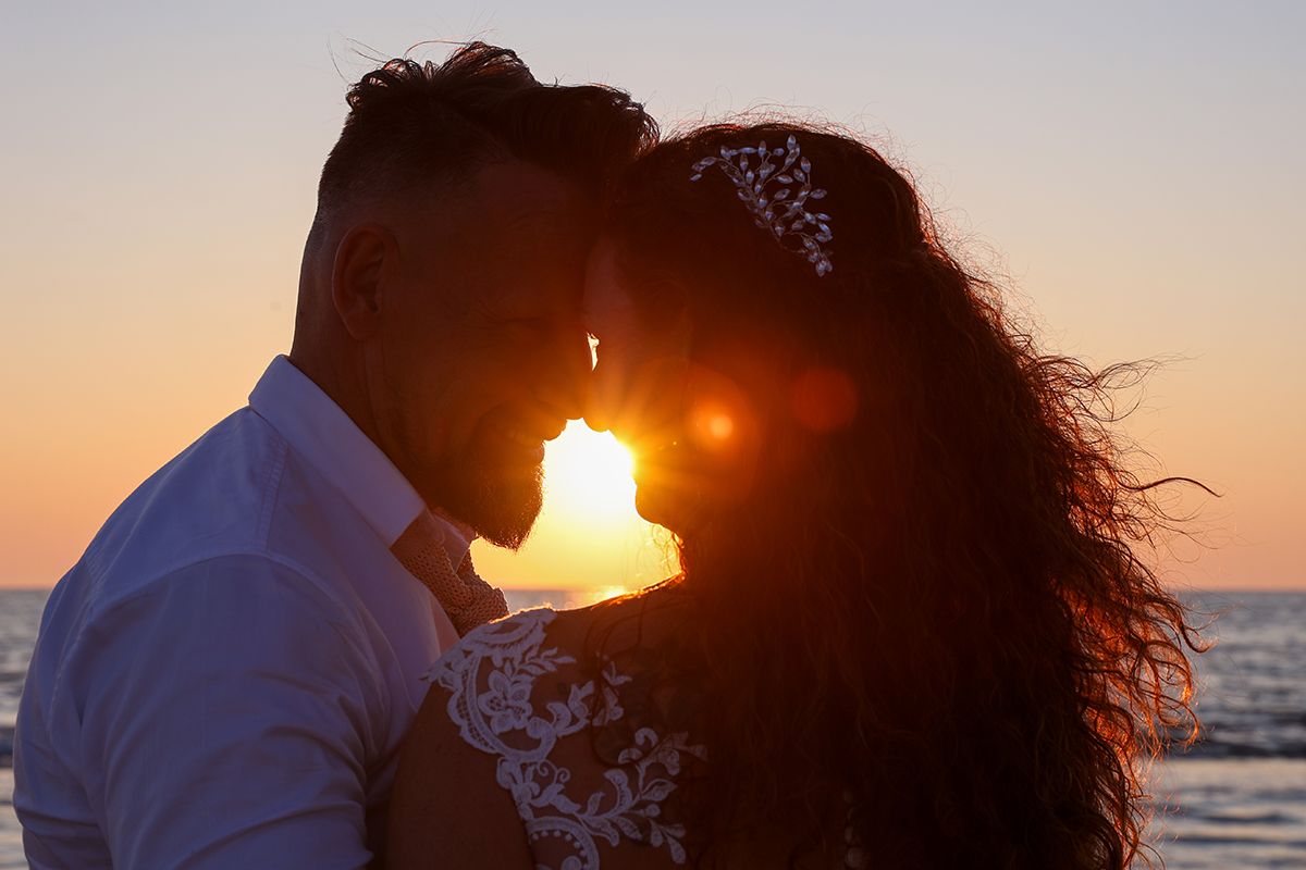 Zonsondergang trouwen op Texel, bruidspaar aan zee bij Paal 17