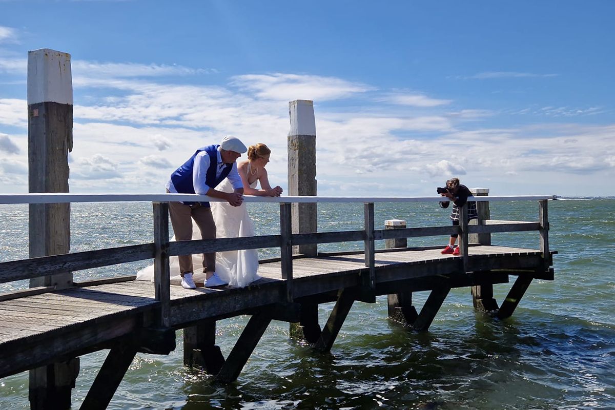 Trouwfotograaf Texel aan het werk op de steiger bij Oudeschild - Foto Sanne