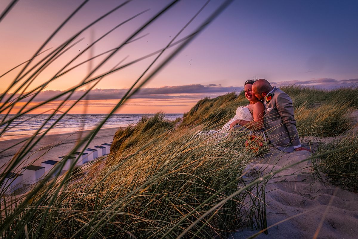 Bruidsfotograaf Texel, bruidspaar met zonsondergang in de duinen van Texel