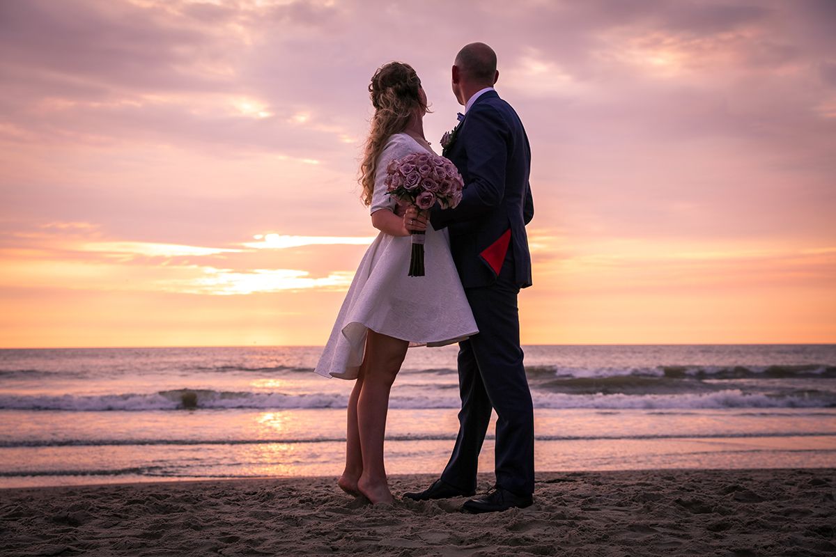 Trouwen op Texel, bruidspaar met zonsondergang aan zee