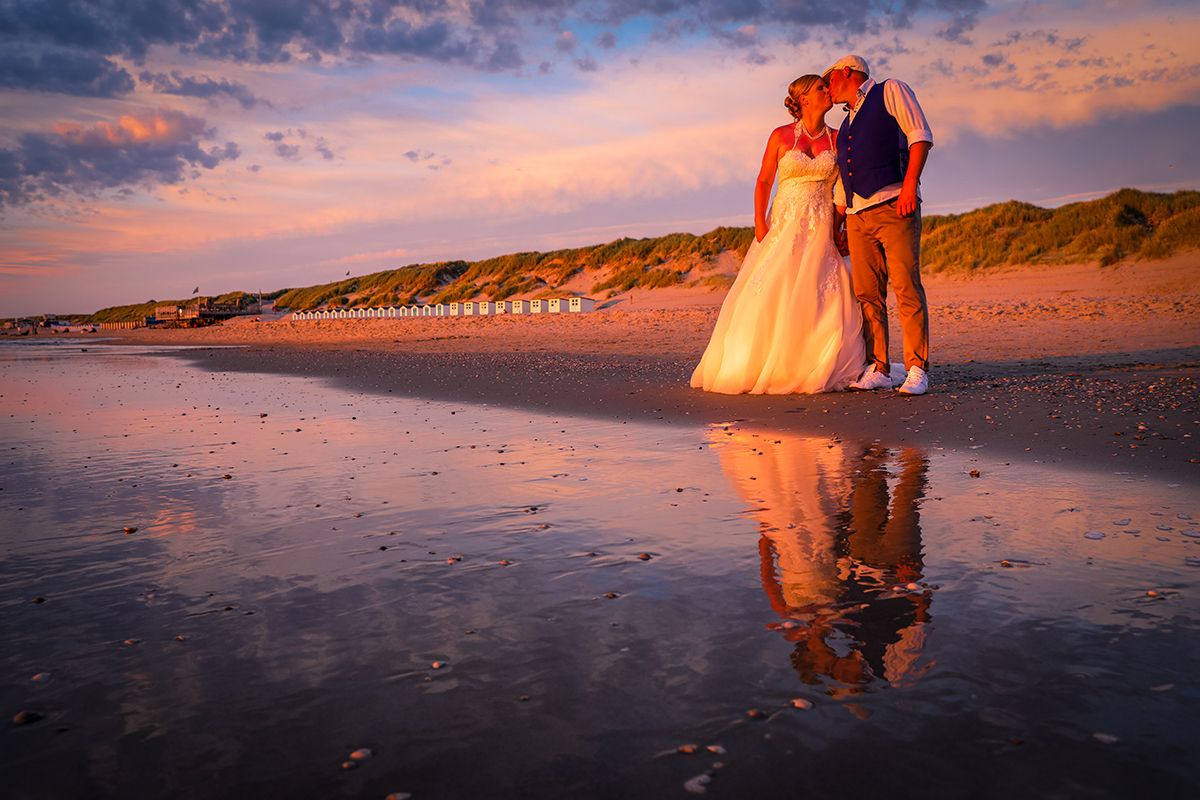 Trouwen op Texel, bruidspaar met zonsondergang, weerspiegeling in zee