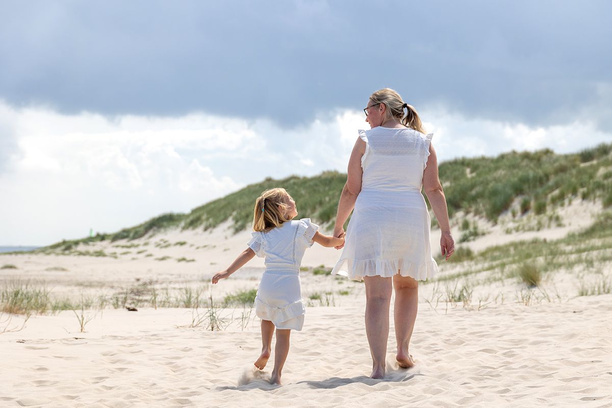 Gezinsfotoshoot op het strand van Texel, aan de wandel met mama