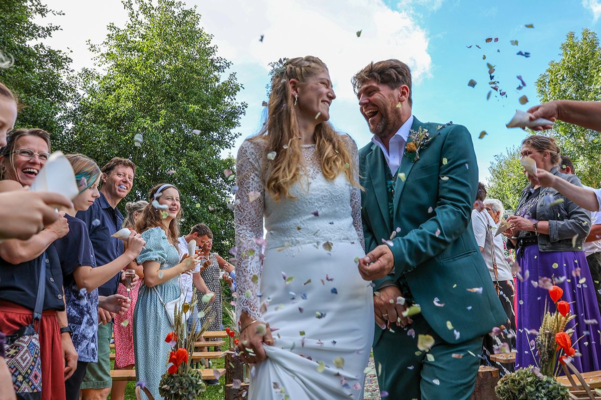 Trouwfotograaf Texel - Foto Sanne met foto van bruidspaar in de confetti van hortensiabloemen